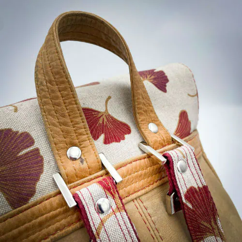 A backpack made from camel colored leather and a red Ginkgo Biloba leaves patterned polycotton canvas.