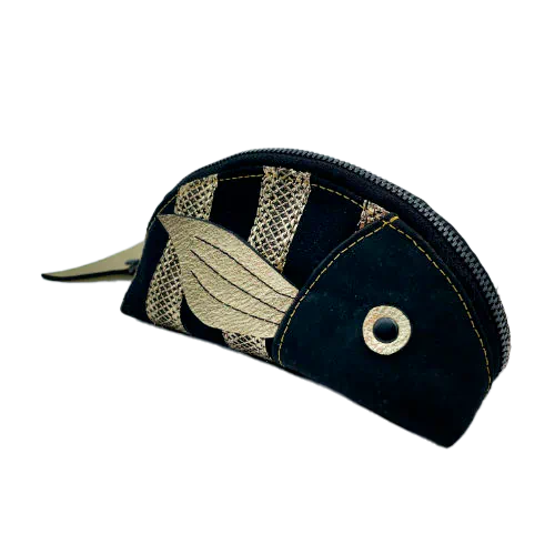 A zippered pouch sewn with black cork, black voile with golden stripes, and golden metallic leather.