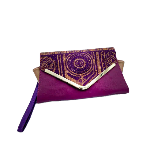 A wallet made from purple and yellow geometrical patterned wrap scrap combined with purple and gold reclaimed faux leathers on the outside, and mustard flax light canvas and deep violet satin on the inside.