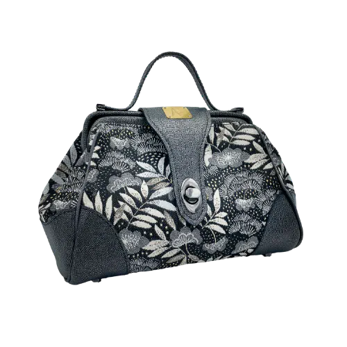 A mini handbag made of black, white, gray, and gold upholstery fabric, combined with anthracite and silver leather.