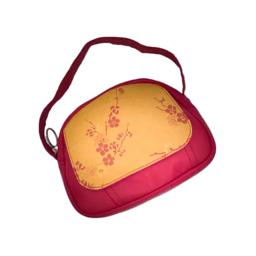 A mini handbag made of yellow upholstery fabric with a red cherry blossom pattern and red leather.