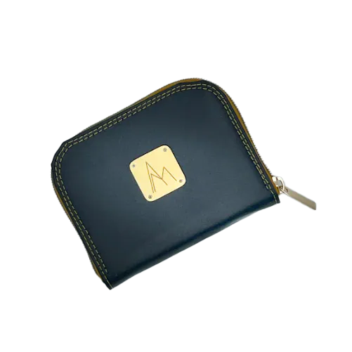 A small zippered card and coin purse made from grape-based material, in a satin black and slightly shimmery color, with a red iridescent lining that reflects purple hues and a black-and-white floral poplin.