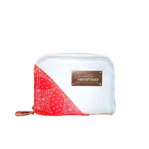 A small zippered card and coin holder made with gradient wrap fabric from orange-yellow to pink, with a pointillist star pattern, and white faux leather.