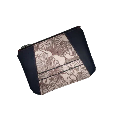 A zippered pouch sewn from a kind of dappled grape leather in brown and a baby-wearing scarf scrap with Ginkgo Biloba patterns in brown on a powdered pink background.