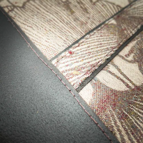 A zippered pouch sewn from a kind of dappled grape leather in brown and a baby-wearing scarf scrap with Ginkgo Biloba patterns in brown on a powdered pink background.