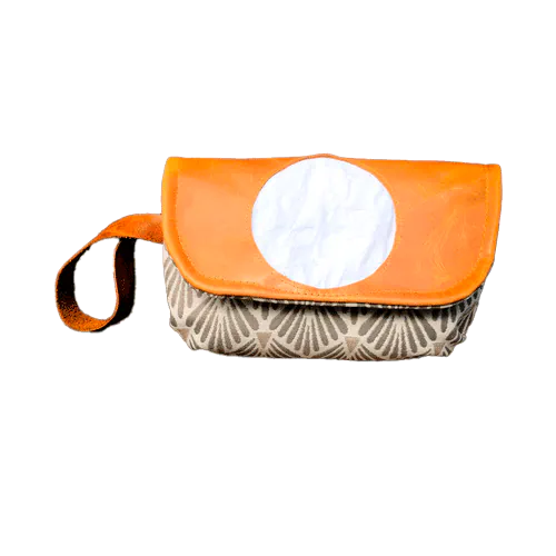 A flap clutch sewn in caramel leather, white damask, and vintage beige and gray patterned fabric, lined with taupe canvas.