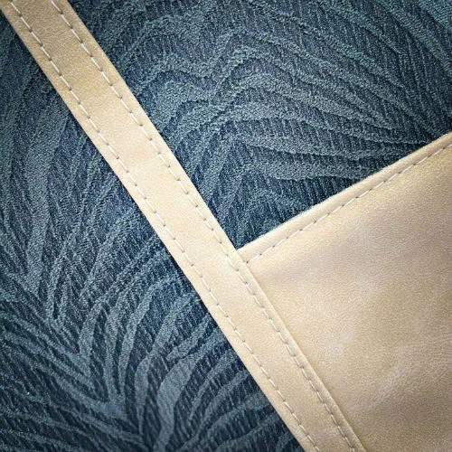 A shoulder bag made from a fabric with the pattern and texture of a forest green tiger fur paired with beige suede-like faux leather, and a lining composed of a high-fashion viscose with very small green and white gingham checks and a cream mottled linen sheet.