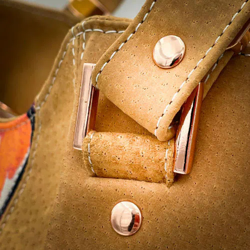 A shoulder bag made of honey-colored pork leather, a floral-patterned pareo, and a turquoise lining.