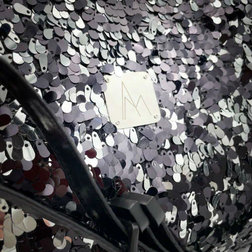 A large shoulder bag made from a black and silver sequin fabric, a grey couture denim, and a fine black faux leather.