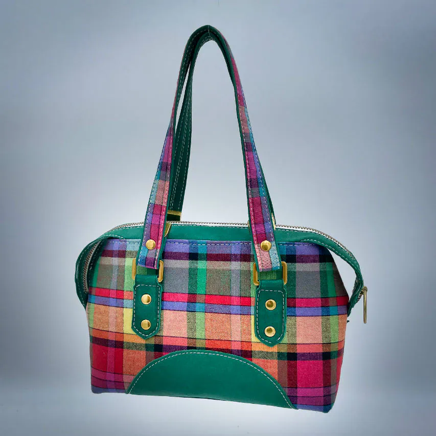 Un sac portefeuille constitué de cuir vert forêt et de toile de madras multicolore.