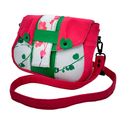 Un sac en bandoulière fabriqué à partir de néoprène aux motifs floraux, d'un crêpe rose fuschia et de cuir grainé vert vif.