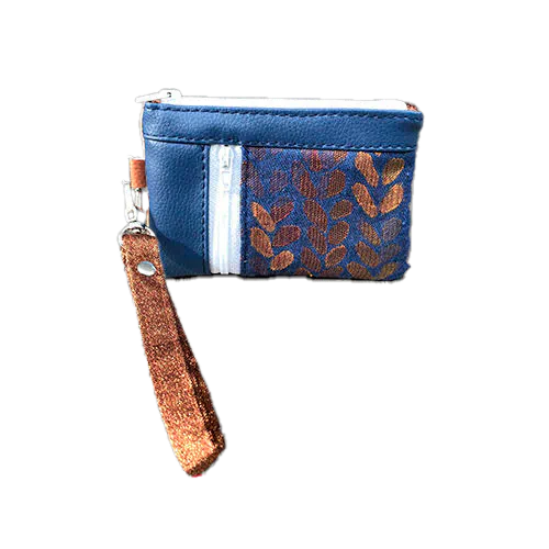 Un mini porte-monnaie zippé composé d'un patchwork de différents matériaux : simili bleu royal, simili doré, tissu bronze brillant et tissu d'écharpe de portage bleu et bronze avec un motif de petites gouttes.
