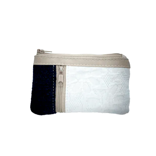 Un petit porte-monnaie zippé fabriqué à partir d'un pull en laine bleu marine, d'un tissu damassé blanc et d'un simili suédé beige.
