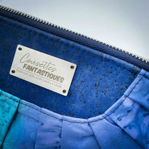 Une pochette zippée cousue dans un foulard en soie dans les tons bleus, plissé et associé à du liège bleur roi.