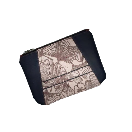 Une pochette zippée cousue dans une sorte de peau pommelée de couleur brun et un coupon d'écharpe de portage au motif de Ginkgo Biloba bruns sur fond rose poudré.