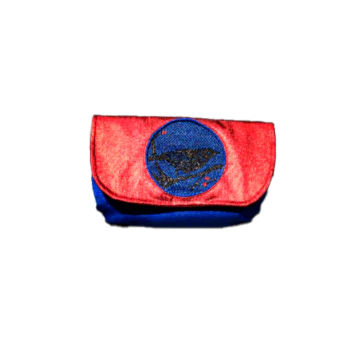 Une petite pochette à rabat cousue en toile bleue, denim enduit rouge métallisé et écharpe de portage au motif aviaire à paillettes, doublée de satin doré.