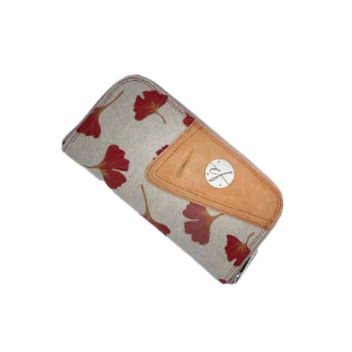 Un porte-cartes-et-monnaie zippé fait de cuir de couleur camel et d'une toile en polycoton avec un motif de feuilles de Ginkgo Biloba rouges.