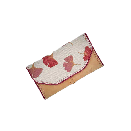 Un portefeuille fabriqué avec du cuir de couleur camel et une toile en polycoton avec un motif de feuilles de Ginkgo Biloba rouges.