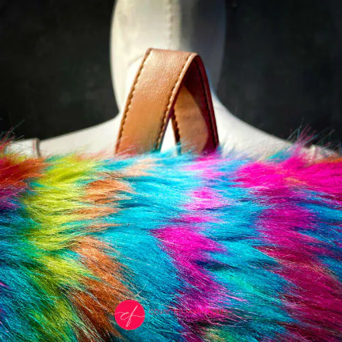 Un sac à dos fabriqué à partir de simili blanc et de fausse fourrure arc-en-ciel.
