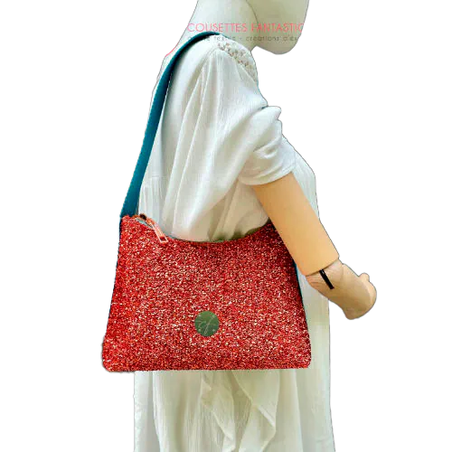 Un petit sac bandoulière zippé fabriqué à partir d'un tissu extensible avec du bouclé métallique cuivré, du simili bleu turquoise, et une doublure orange clair lumineuse.