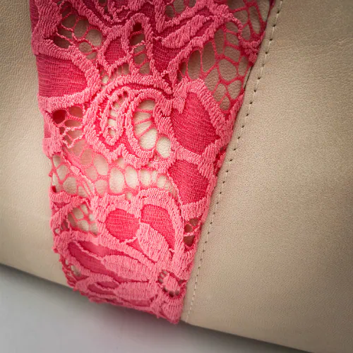 Un sac d'épaule composé de cuir de chèvre beige, de dentelle rose corail et d'une doublure gris souris.