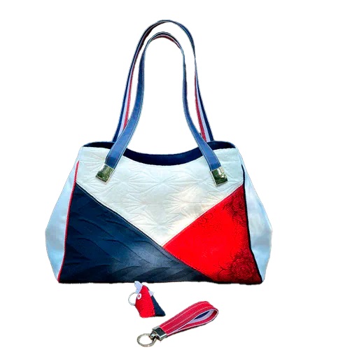 Un sac d'épaule réalisé avec plusieurs coupons d'écharpe de portage (bleu, blanc et rouge) et similis blanc et bleu.