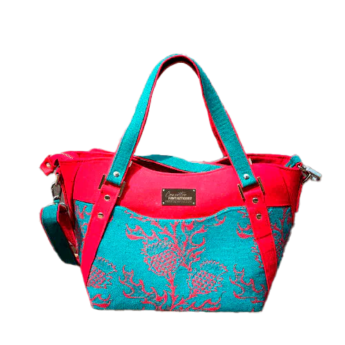 Un sac d'épaule fait avec du tissu d'écharpe rouge sang et vert émeraude au motif de chardons, de la gabardine rouge, de la toile de lin vert émeraude et du simili rouge.