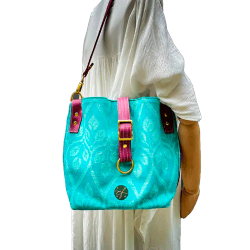 Un sac d'épaule en tissu d'écharpe turquoise et écru à motif de feuilles, simili prune et popeline menthe irisée.
