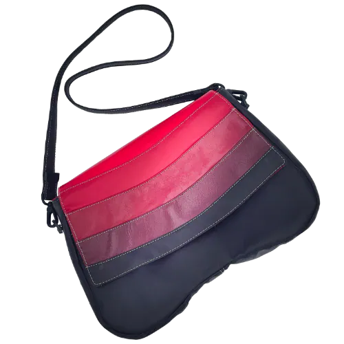 Un sac d'épaule composé de cuirs de différentes teintes de rouge, un marron et une doublure rouge.