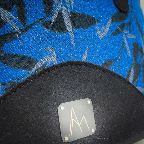 Un sac d'épaule confectionné à partir d'écharpe de portage au motif de bambous noir et bleu roi, d'un drap de laine bouillie noire et d'un cuir texturé à paillettes, couplés à un satin gris bleuté à l'intérieur.