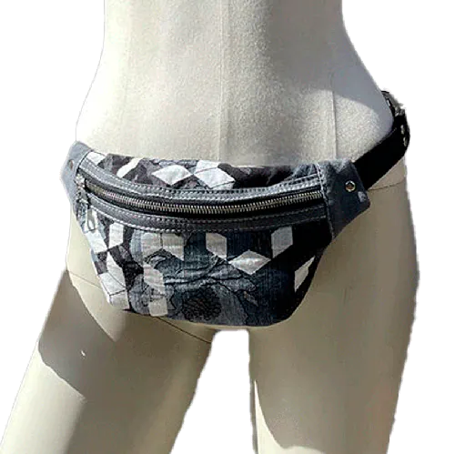 Une banane en tissu d'écharpe de portage aux tons gris, blanc et bleu avec un motif floral et géométrique et en denim gris.