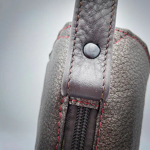 Un sac à main composé de cuir métallisé et une doublure en satin rouge irisé.