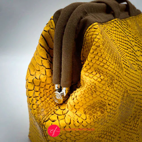 Un sac à main fait avec du simili texture croco, coloris jaune et marron.
