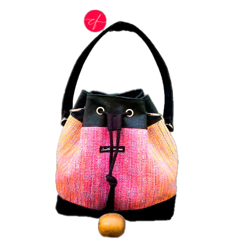 Un sac d'épaule fait en écharpe de portage dégradé miroir rose à bleu et liège noir.