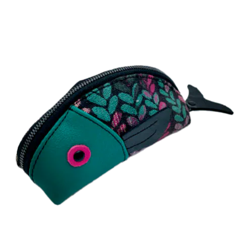 Une pochette zippée cousue dans un cuir vert sauge, un cuir vernis noir, un cuir rose fuschia et deux chutes d'écharpe de portage au motif de mailles vertes, beiges et roses sur fond noir.