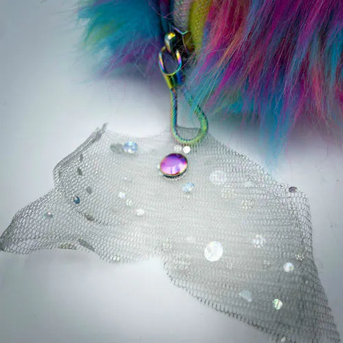 Une pochette zippée cousue dans du simili cuir blanc à paillettes, de la fausse fourrure arc-en-ciel, et du tulle à sequins iridescents.